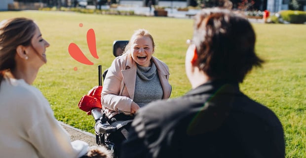 Care worker talking in a park with disabled friends