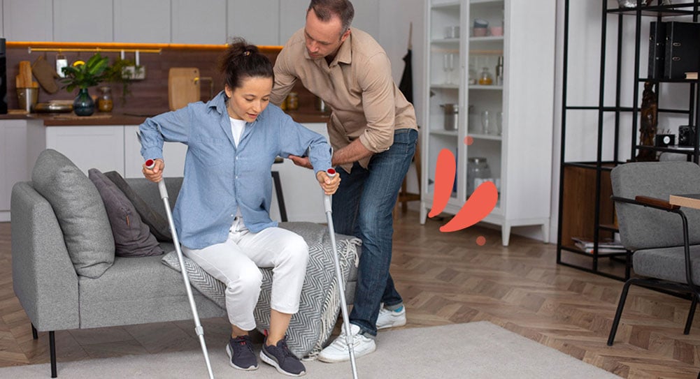 Care worker assisting individual with crutches during injury recovery
