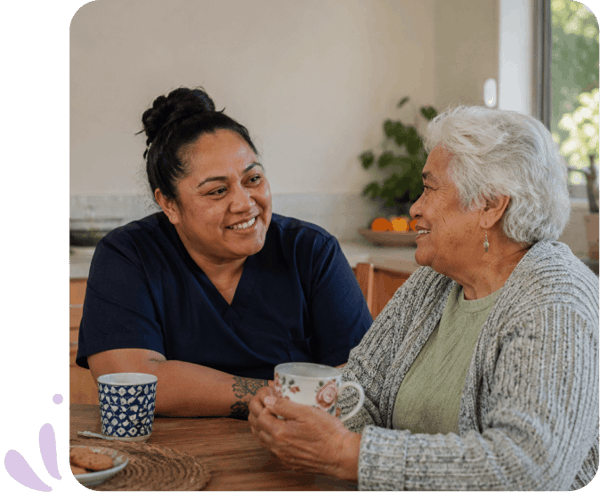 Carer having a cup or tea with elderly woman